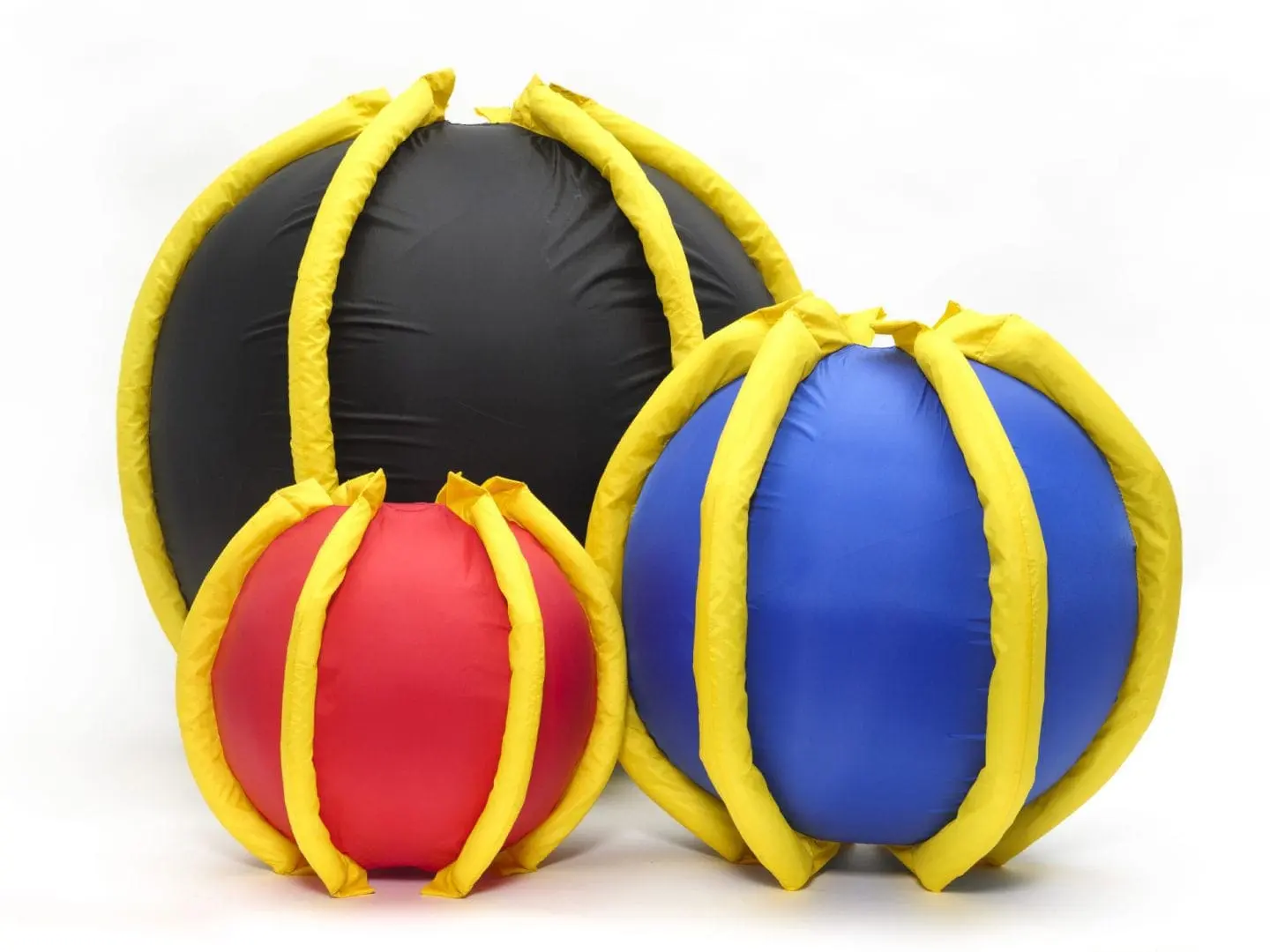 Three inflatable balls in red, blue, and black with yellow ribbing.