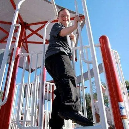 Young person climbing on playground equipment.