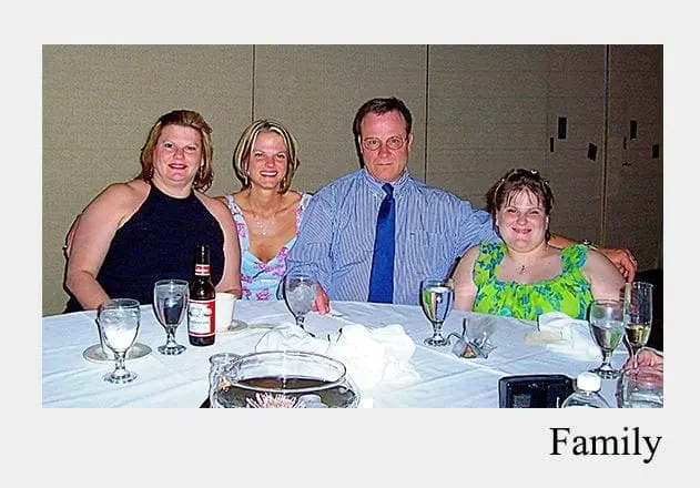 Four people sit at a table set for a meal.