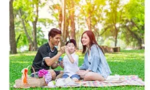 Family having a picnic in a park on a sunny day.