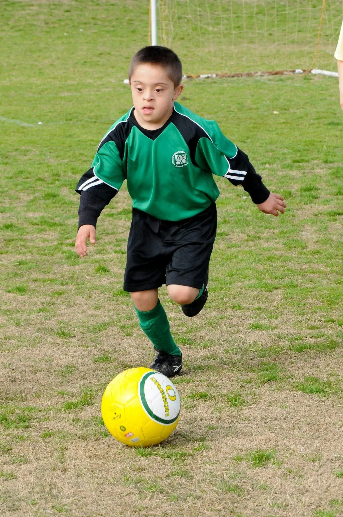 Boy with Down syndrome playing soccer.