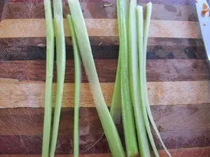 Celery stalks and cut pieces on a wooden cutting board