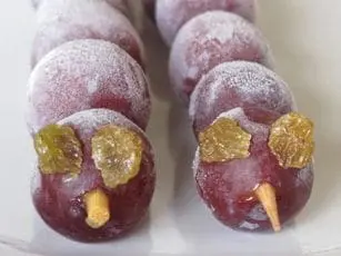 Two frozen grape caterpillars with raisin eyes and wooden skewer bodies.