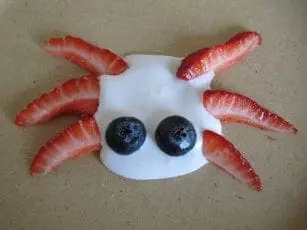Silly creature made of whipped coconut cream, blueberries, and strawberries.