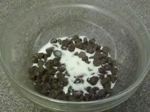 Chocolate chips and milk in a glass bowl for fondue.