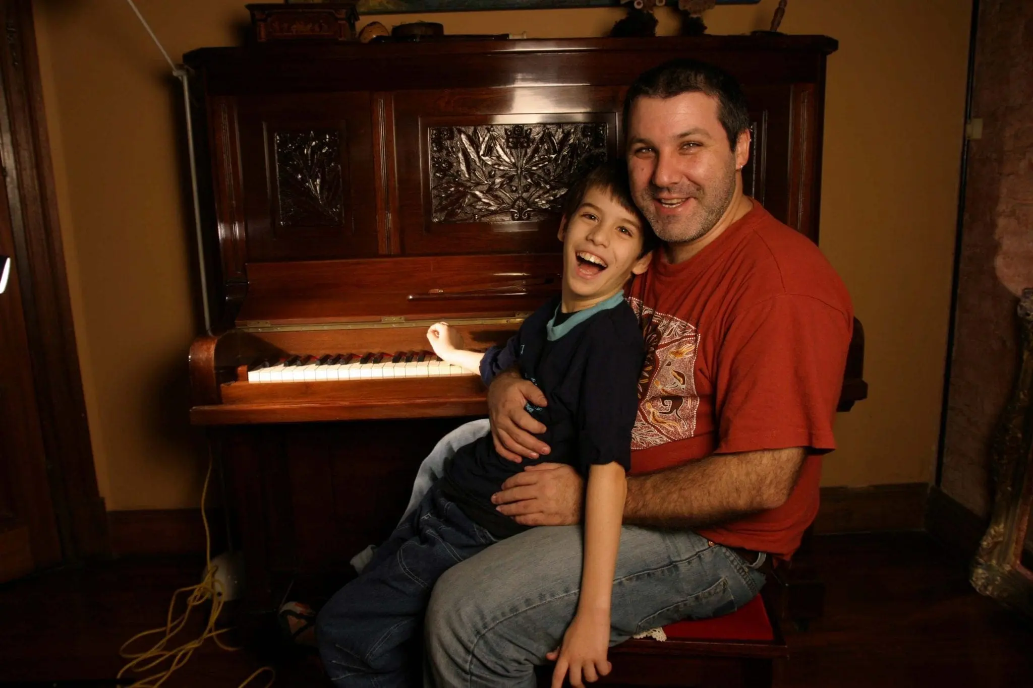 Gabriel Federico sitting with his son Matias in front of a piano.