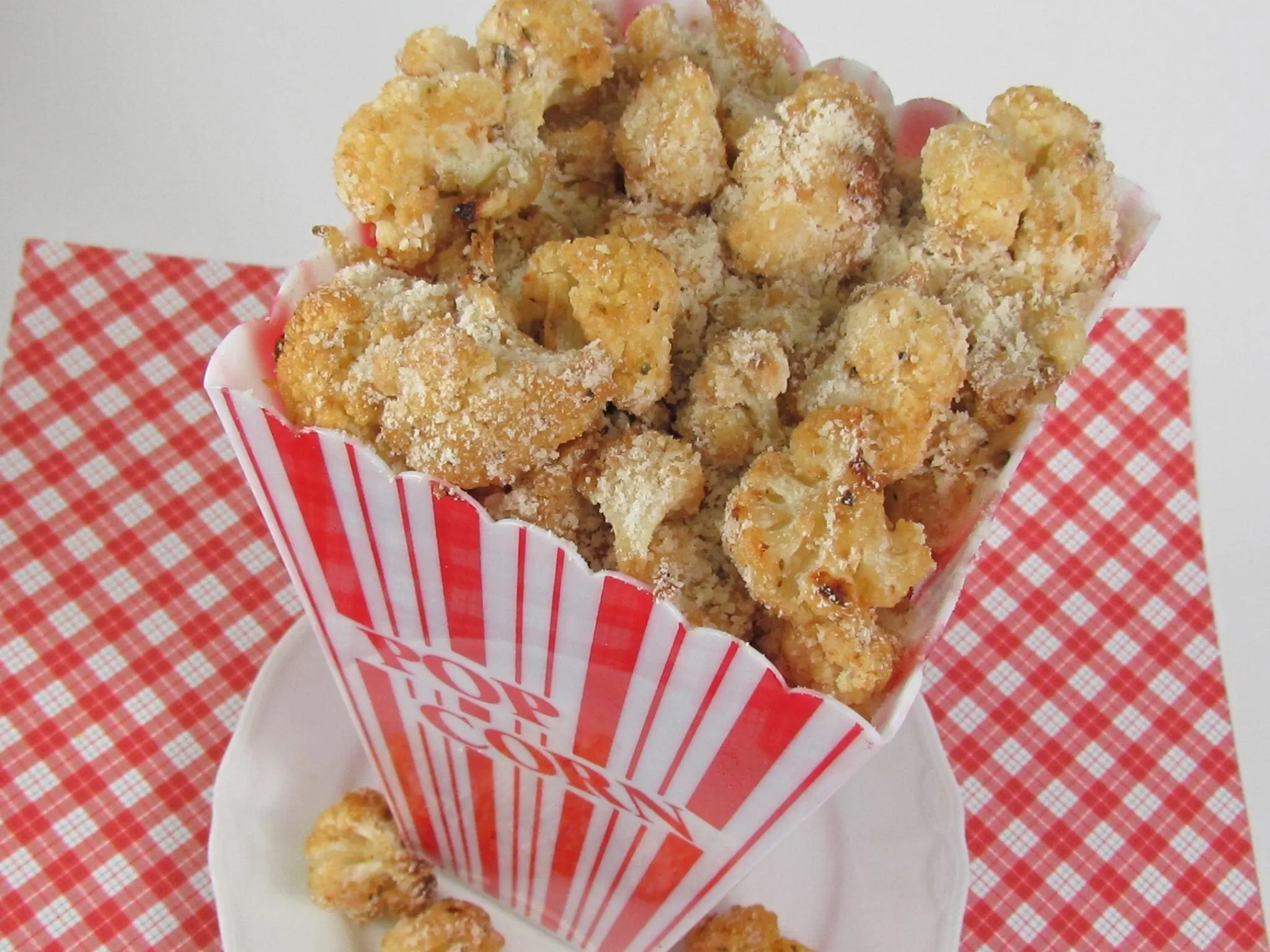 Cauliflower popcorn in a red and white striped container.