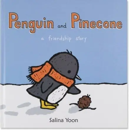 Cover of the book "Penguin and Pinecone" showing a penguin with an orange scarf looking at a pinecone on the snow.