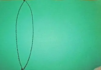 A black crayon draws a large oval on a green background.