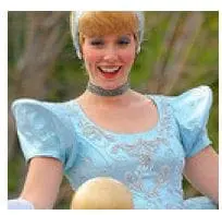 Cinderella in a blue ball gown and choker smiles broadly.