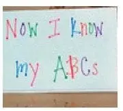A whiteboard displays "Now I Know my ABCs" written in colorful letters.