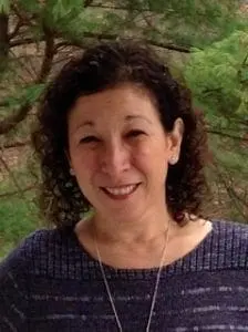 Sue Wachta smiling with trees in the background.