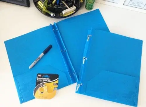 Two blue folders and a marker on a table