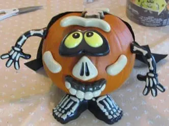 A Halloween pumpkin decorated with a skeleton push-in kit.