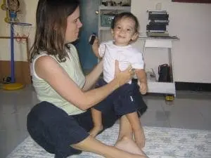 Woman and child doing the butterfly stretch exercise.