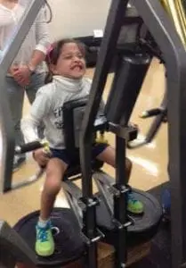 Chloe using exercise equipment with a determined expression.