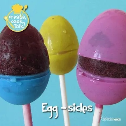Three egg-shaped frozen treats on sticks against a blue background.