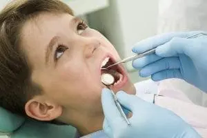Young boy having his teeth examined by a dentist.