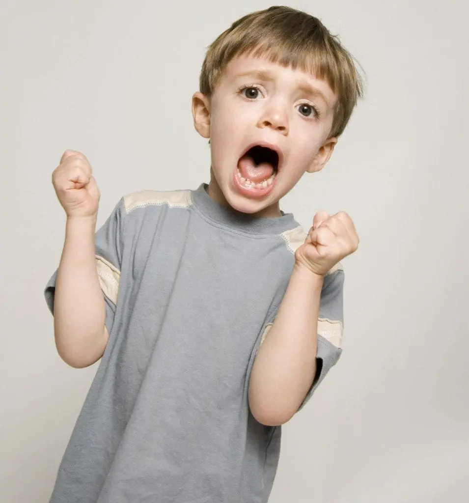 Young boy with arms raised and mouth open in distress.
