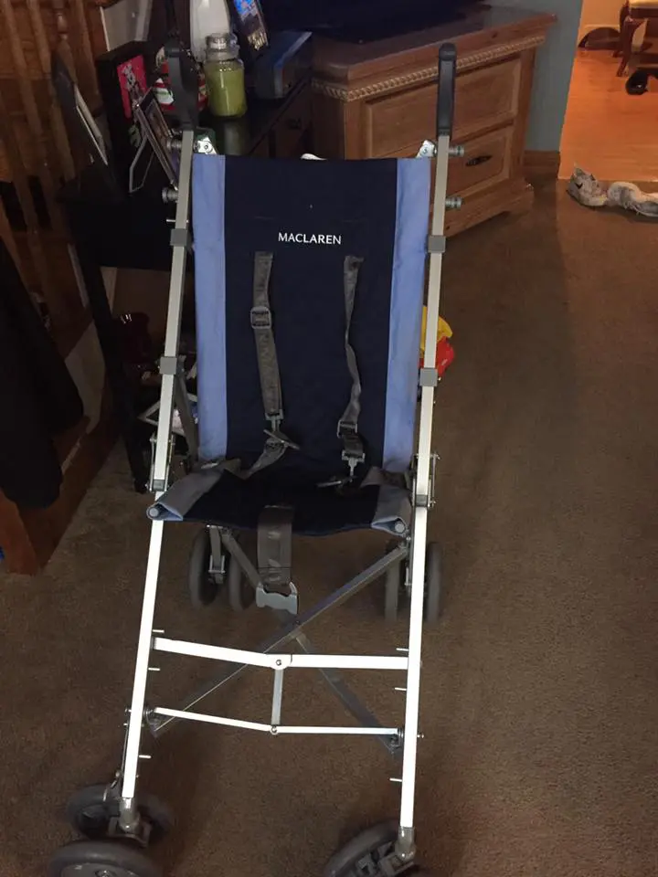 Maclaren stroller with blue fabric seat and harness.