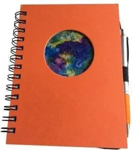 Orange journal with a circular window showing abstract art and a pen.