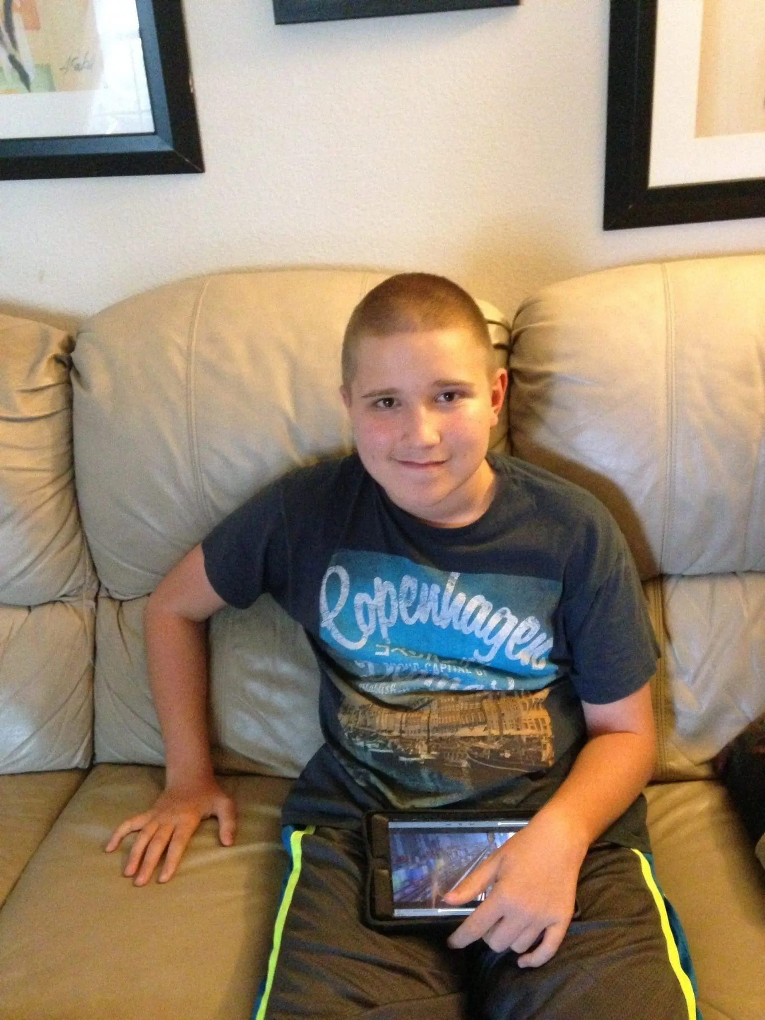 Richie sitting on a couch holding an iPad.
