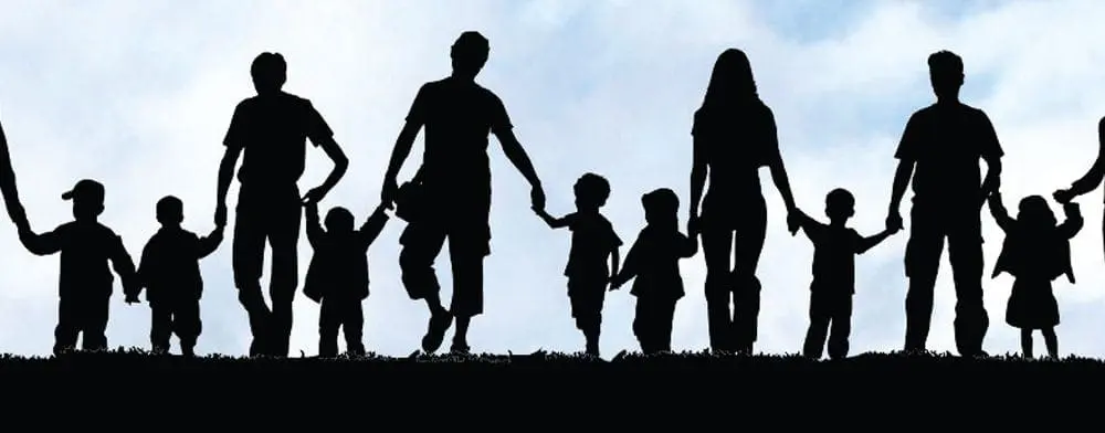 Silhouettes of families holding hands against a cloudy sky