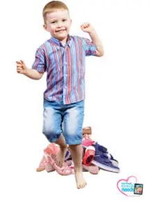 Young boy jumping over a pile of shoes.
