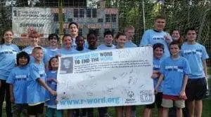 Group of children and teens wearing blue t-shirts and holding a sign that says "Spread the Word to End the Word.