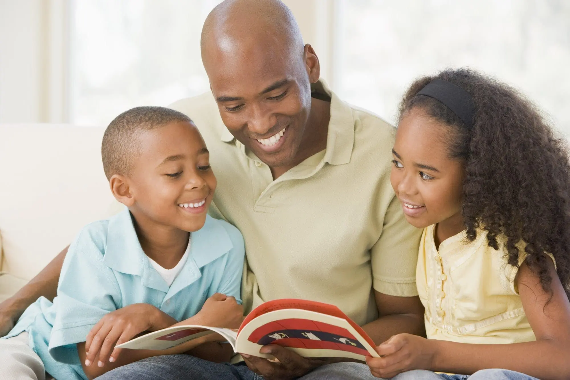A father reads with his two children.