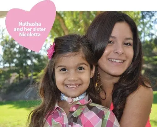 Two smiling sisters, Nathasha and Nicoletta, are pictured outdoors with a pink heart graphic overlay.