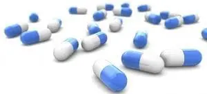 Blue and white capsules scattered on a white surface.