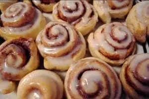 Several cinnamon rolls topped with white icing.