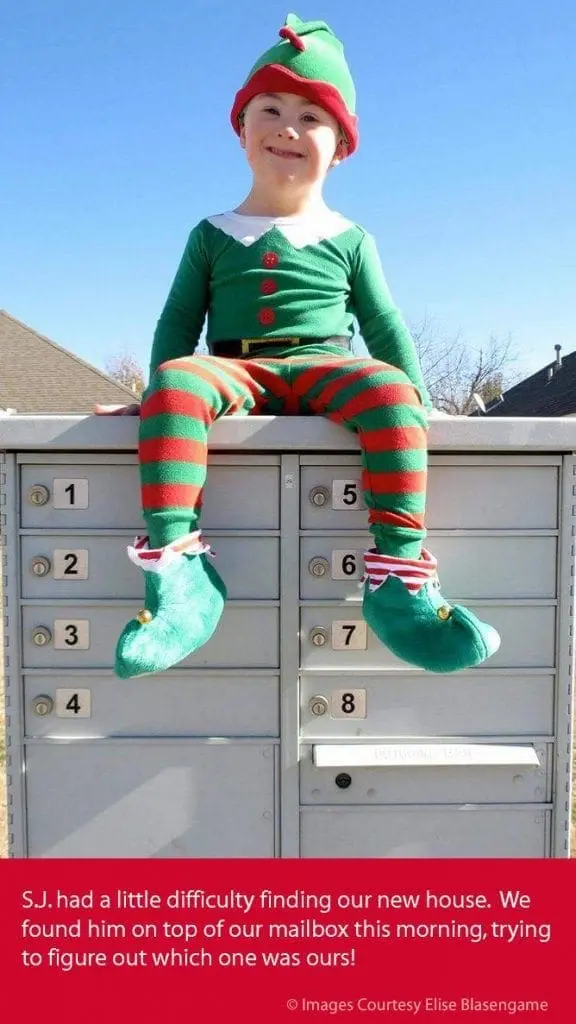 Child dressed as an elf sitting on a multi-unit mailbox.