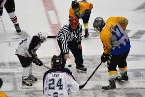 Hockey players and referee at a face-off during a game.