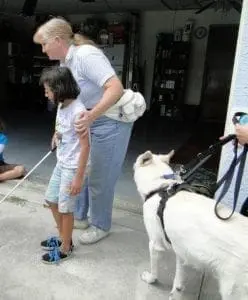 Torrie Jody with a young girl and a service dog.