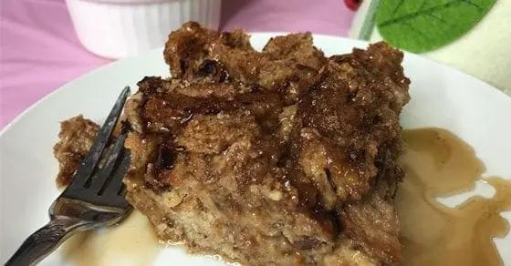 Slice of peanut and apple butter French toast bake with syrup on a white plate.