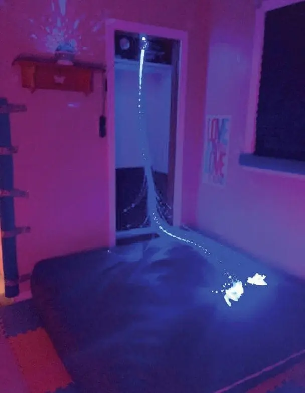A crash mat in a room with purple lighting and fiber optic strands.