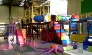 Indoor playground with slides and climbing structures.