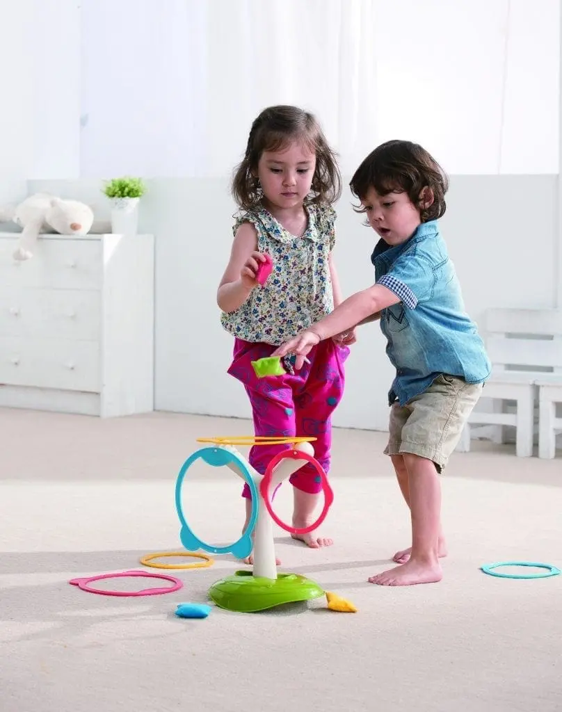 Two young children play with a colorful toy designed for movement.