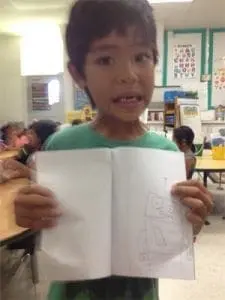 Leandro holds open a drawing of a robot.