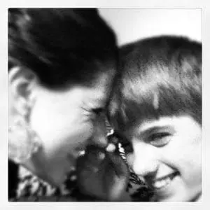 Two people touching foreheads and smiling.