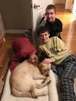 Three boys with a yellow Labrador Retriever named Monty.