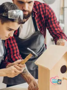 Man and boy build a birdhouse together.
