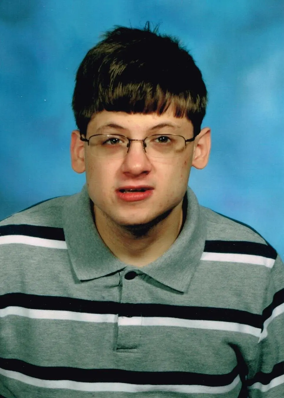 Tony Mancuso wearing a striped polo shirt and glasses.
