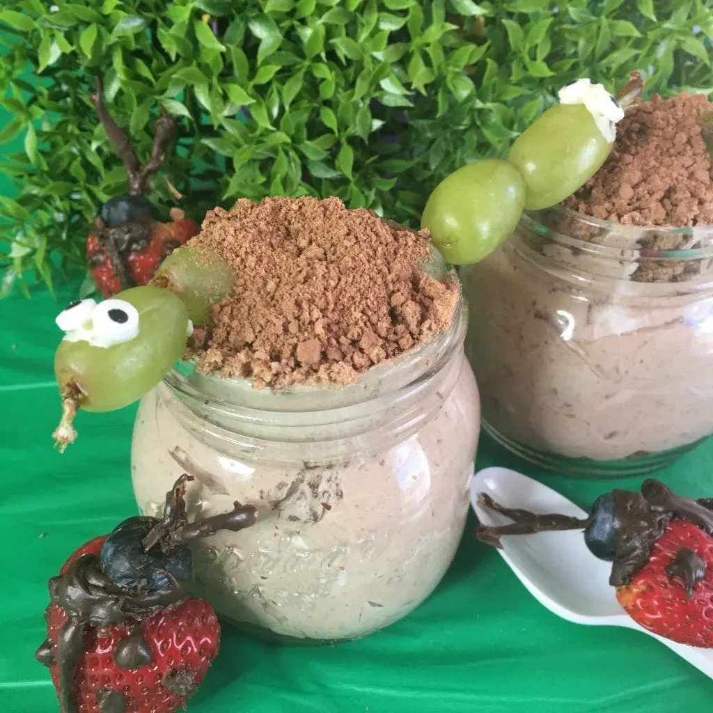 Dirt cups in jars with a grape worm and chocolate-dipped strawberries.