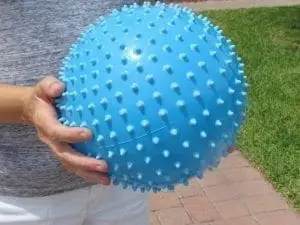 Blue textured fitness ball held by a person
