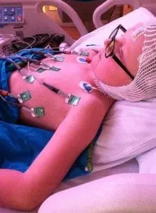 Jordan in a hospital bed with medical monitoring equipment attached.