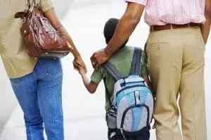 Parents walking with their child to school
