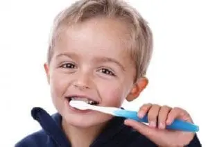 Child brushing teeth with a blue and white toothbrush.